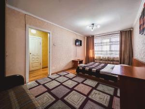 Habitación de hotel con cama y ventana en Тасс уютная квартира в центре города, en Petropavlovsk