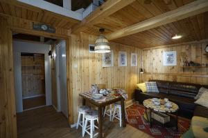 salon z kanapą i stołem w obiekcie Sosnowy Zakątek - domek wakacyjny nad jeziorem w lesie w mieście Tuczno