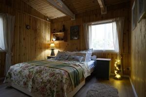 1 dormitorio con cama y ventana en Sosnowy Zakątek - domek wakacyjny nad jeziorem w lesie en Tuczno