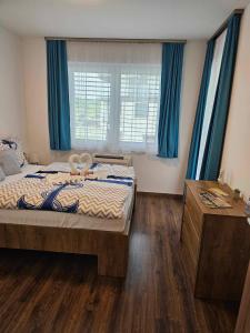- une chambre avec un grand lit et des rideaux bleus dans l'établissement Residence Port Royal, à Keszthely