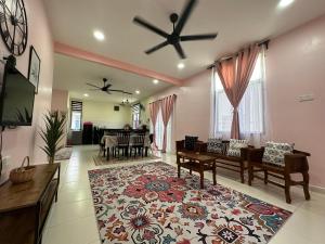 uma sala de estar com uma ventoinha de tecto e uma televisão em CassaNeyna Homestay Kuantan em Kuantan