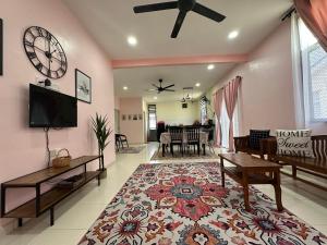 a living room with a clock on the wall at CassaNeyna Homestay Kuantan in Kuantan