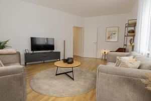 uma sala de estar com dois sofás e uma mesa em Geräumige Design Oase ideal für Gruppen & Familien em Stuttgart