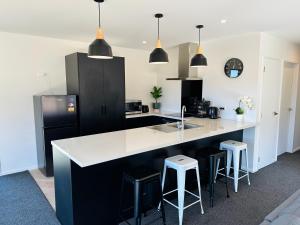 een keuken met een zwart-wit aanrecht en krukken bij Manuka Vista in Twizel