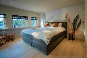 a bedroom with a large bed with a painting on the wall at B&B de oude melkfabriek in Valkenswaard