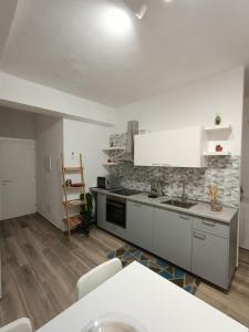 uma cozinha com armários brancos e uma bancada em Appartamento Violet - Parma em Parma