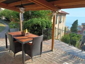 Une table et des chaises en bois sont disponibles sur la terrasse. dans l'établissement Casetta Mami, à Camogli