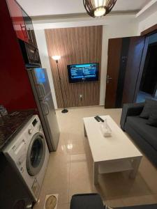 sala de estar con sofá, mesa y TV en apartment 60m 1bedroom for rent3 en Umm Uthainah