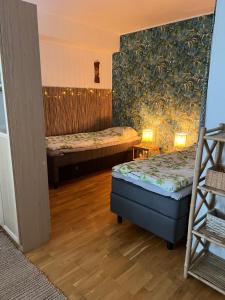 a room with two beds in a room with wooden floors at Cityflat Saimaa in Lappeenranta