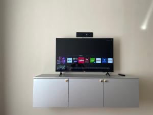 TV de pantalla plana en la parte superior de un armario blanco en Dream City 15, en Astana