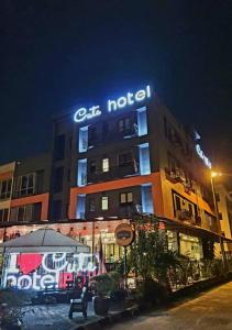 a building with a lit up sign on top of it at Cute Hotel & Dorms Ipoh in Ipoh