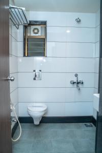 a bathroom with a toilet and a window at Hotel Dreamland in Pune