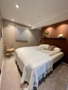 Luxury apartement close to city centre with free parking في ترومسو: غرفة نوم بسرير كبير مع بطانية بيضاء