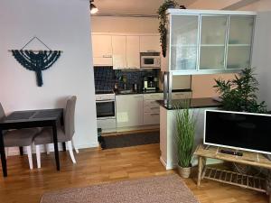 a kitchen and dining room with a table and a television at Cityflat Saimaa in Lappeenranta
