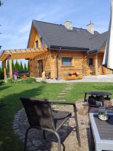a log cabin with a chair in front of it at Dom z bala w sercu Podlasia in Białystok