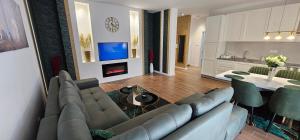 a living room with a couch and a table and a fireplace at Lux Apartmani Novi Park in Vrdnik