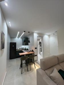 a kitchen and living room with a couch and a table at ZELUN Suite Torremolinos Center in Torremolinos