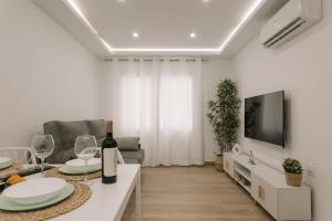 a living room with a table with wine glasses and a tv at Apartamento MARCO a 250m playa in Calpe
