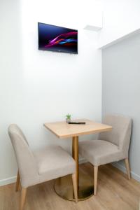 uma mesa e duas cadeiras num quarto em Nets Inn Apartments - Buttes Chaumont D em Paris