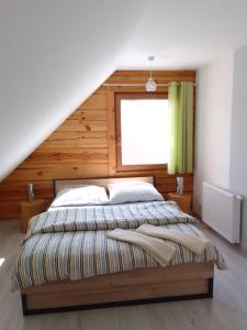 a bedroom with a large bed with a wooden wall at Dom z bala w sercu Podlasia in Białystok