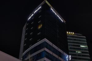 a tall building with a sign on the top of it at Hotel Haydn in Busan