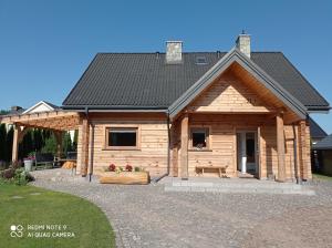 Cette cabane en rondins dispose d'une terrasse couverte. dans l'établissement Dom z bala w sercu Podlasia, à Białystok