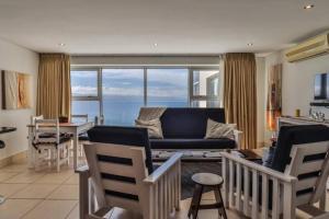 a living room with a couch and a table with chairs at Nautical views in Mossel Bay