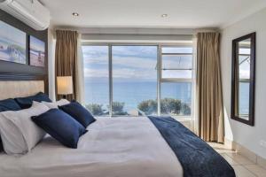 a bedroom with a large bed with a large window at Nautical views in Mossel Bay