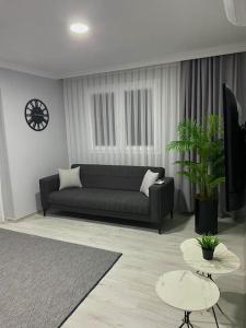 una sala de estar con un sofá negro y una planta en Turgutsluxury 3, en Fethiye