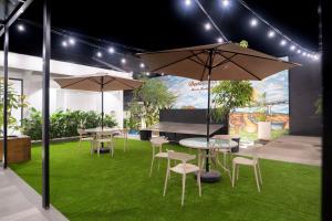 The Difan Hotel في جامبي: مجموعة طاولات وكراسي مع مظلات على العشب