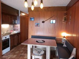 eine Küche mit Holzwänden und einem Holztisch mit Stühlen in der Unterkunft Appartement chalet en plein centre des Saisies in Hauteluce