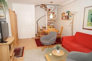 a living room with a red couch and a table at Penthousewohnung vor der Promenade in Damp