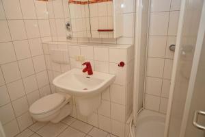 a white bathroom with a toilet and a sink at Penthousewohnung vor der Promenade in Damp