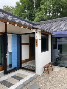 mały domek z ławką przed nim w obiekcie Bow Hanok House w mieście Gangneung