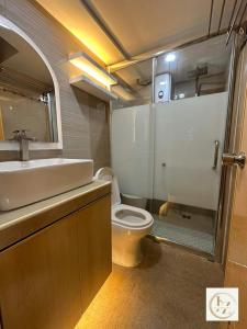 a bathroom with a toilet and a sink and a shower at J&Z Escape Staycation in Manila