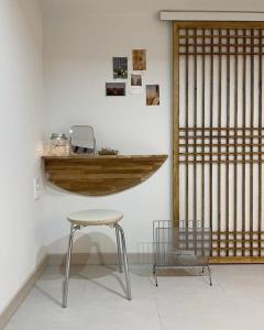 una mesa y un taburete en una habitación con una pared en Bow Hanok House, en Gangneung