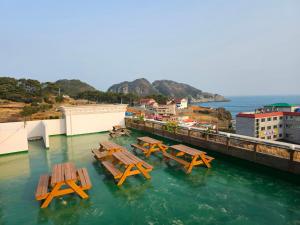 un grupo de mesas de picnic en el agua en Pataya Motel en Geoje 