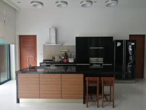 a kitchen with a black counter and two chairs at AP HOUSE in Bangkok