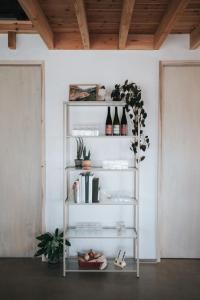 a shelf with wine bottles and books in a room at Pañ boetiek BnB in Zele