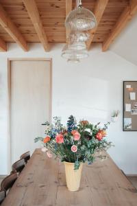 um vaso de flores sentado numa mesa de madeira em Pañ boetiek BnB em Zele