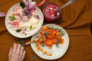 zwei Teller Essen auf einem Tisch mit einer Person, die Lebensmittel zubereitet in der Unterkunft Pañ boetiek BnB in Zele