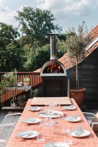 a wooden table with a fireplace on a patio at Pañ boetiek BnB in Zele