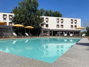 a large swimming pool in front of a hotel at Belstay Milano Linate in Peschiera Borromeo