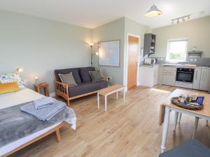 a room with a bed and a couch and a kitchen at The Wheelhouse in Carinish