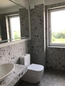 a bathroom with a white toilet and a sink at Komfort & Wodna Dolina in Koszalin +7 photos