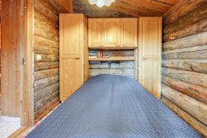 a room with a bed in a wooden cabin at Kelohonkahuoneisto Käkriäinen B in Kemijärvi