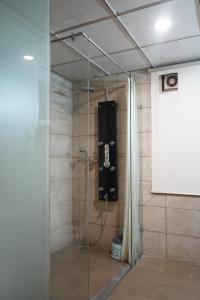 a room with a shower with a black guitar case in it at THE KALINGA INN in Rohtak