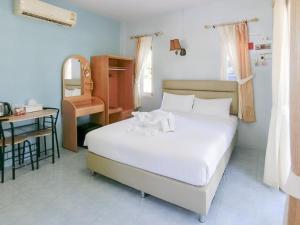 - une chambre avec un lit blanc, un bureau et une chaise dans l'établissement AURA Park Resort, à Ban Thung Sam Sao