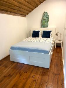 ein Schlafzimmer mit einem weißen Bett mit einer grünen Statue darauf in der Unterkunft Agroturystyka przy Pracowni Malarstwa i Rzeźby 