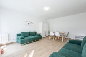 a living room with two green couches and a table at BIG BEN Near Disneyland Paris - Fairytale Factory in Bussy-Saint-Georges